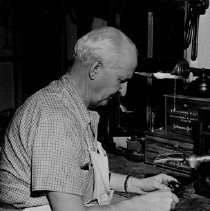 James P. Giern, the "Ger" of Gerholt, smokes his engineer pipe as he works